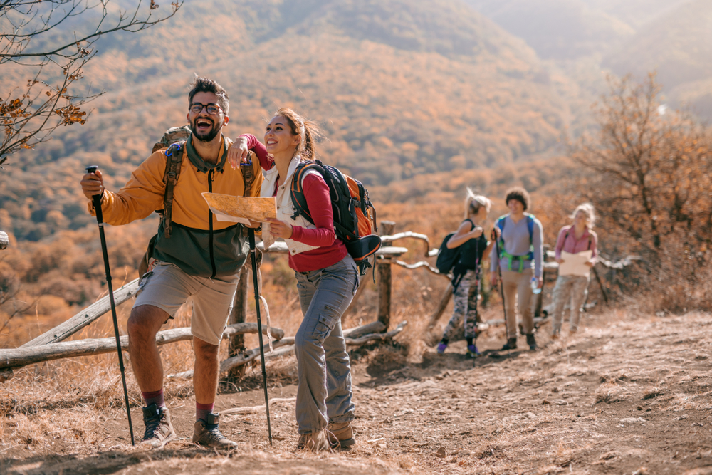 a pair of hikers working together to navigate the mountain
