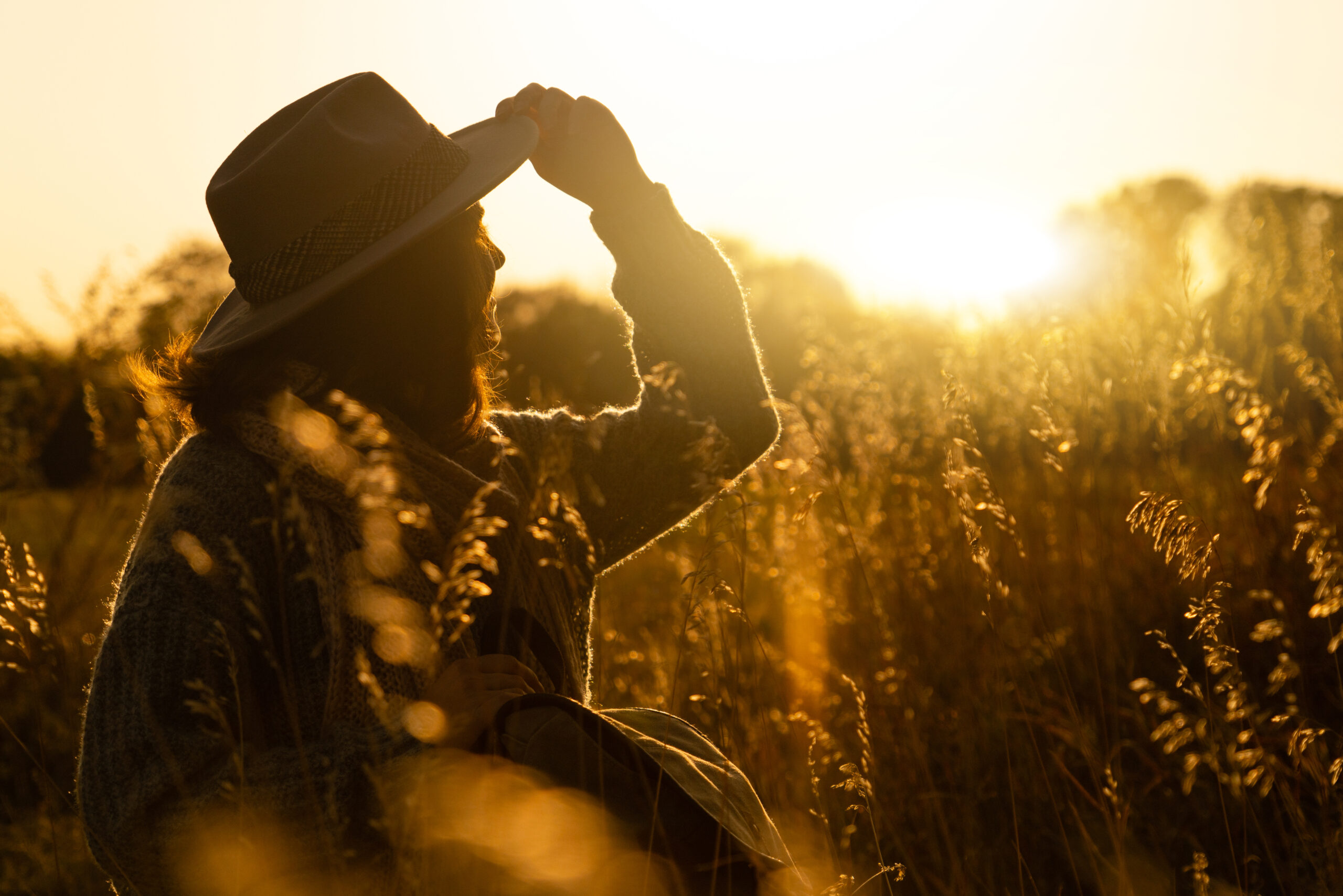 woman sits in a field after a breakup