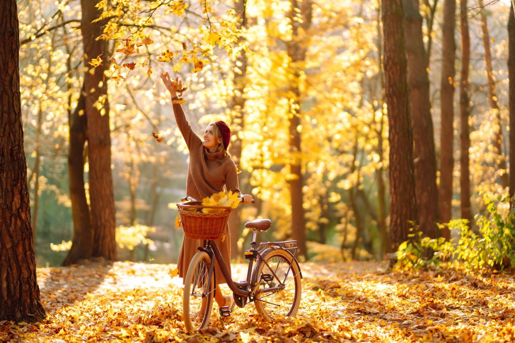 woman on bicycle having fun in autumn park