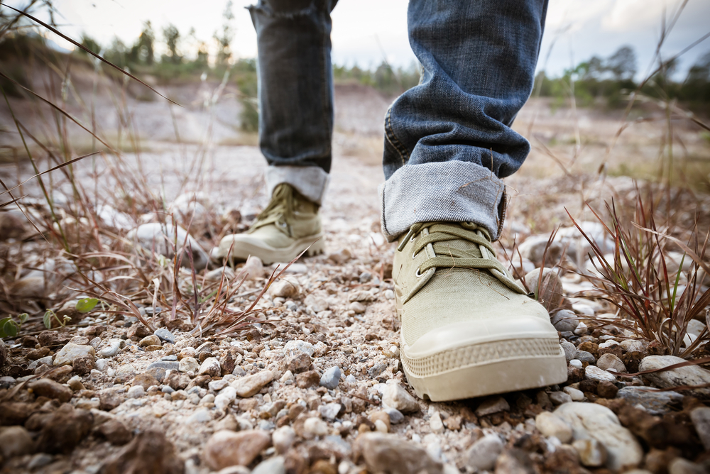 feet of man walking on ground rock