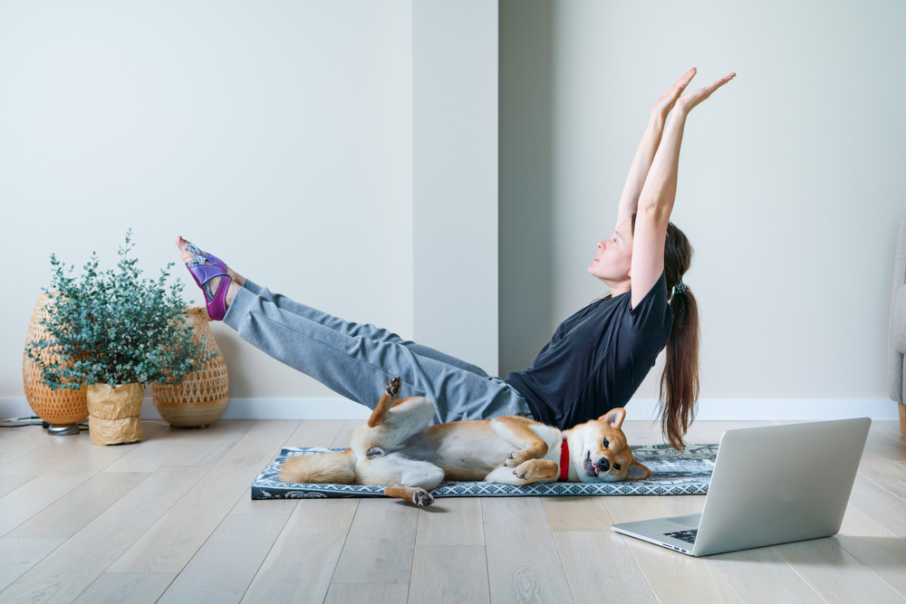 woman in yoga position with her dog