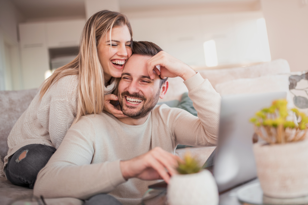 young happy couple looking at a laptop