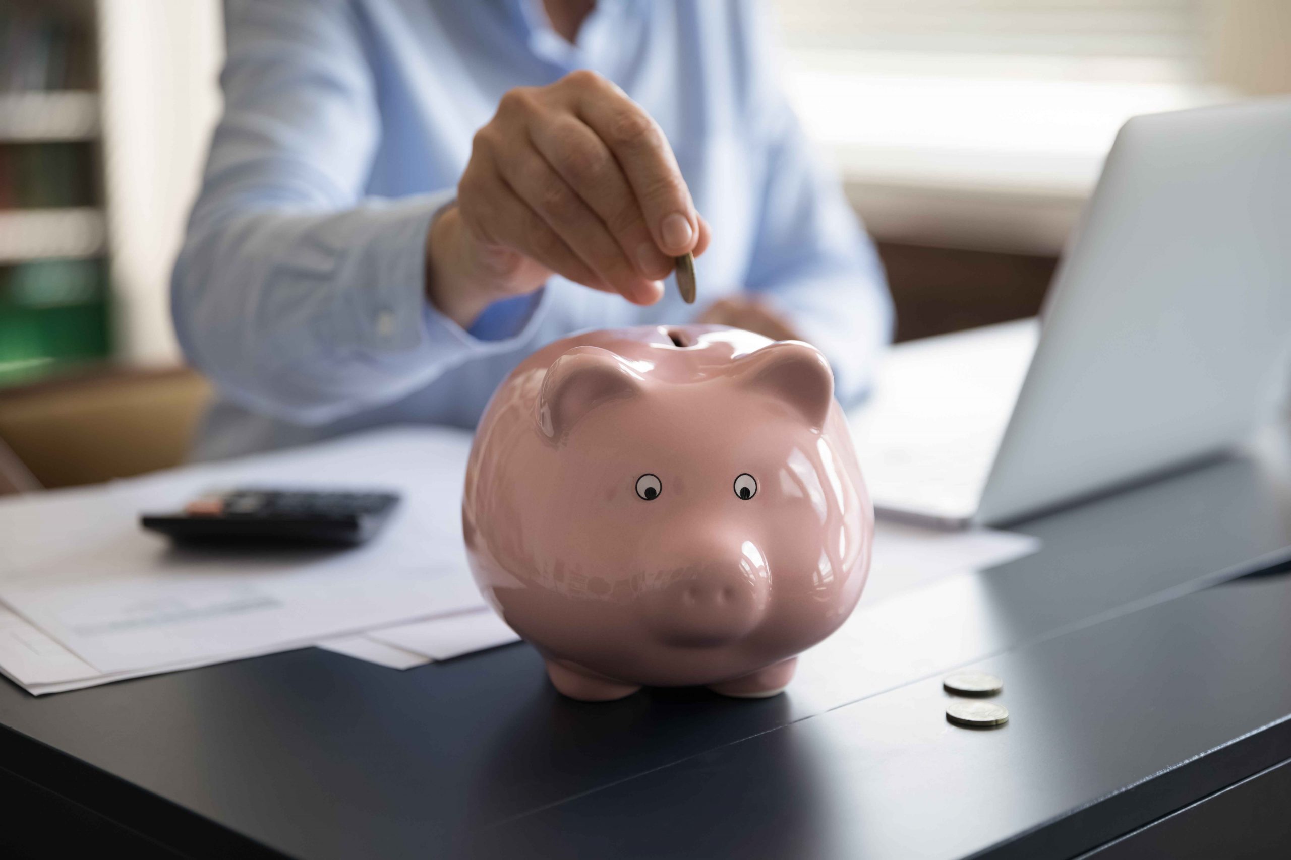 woman putting coin in a piggybank
