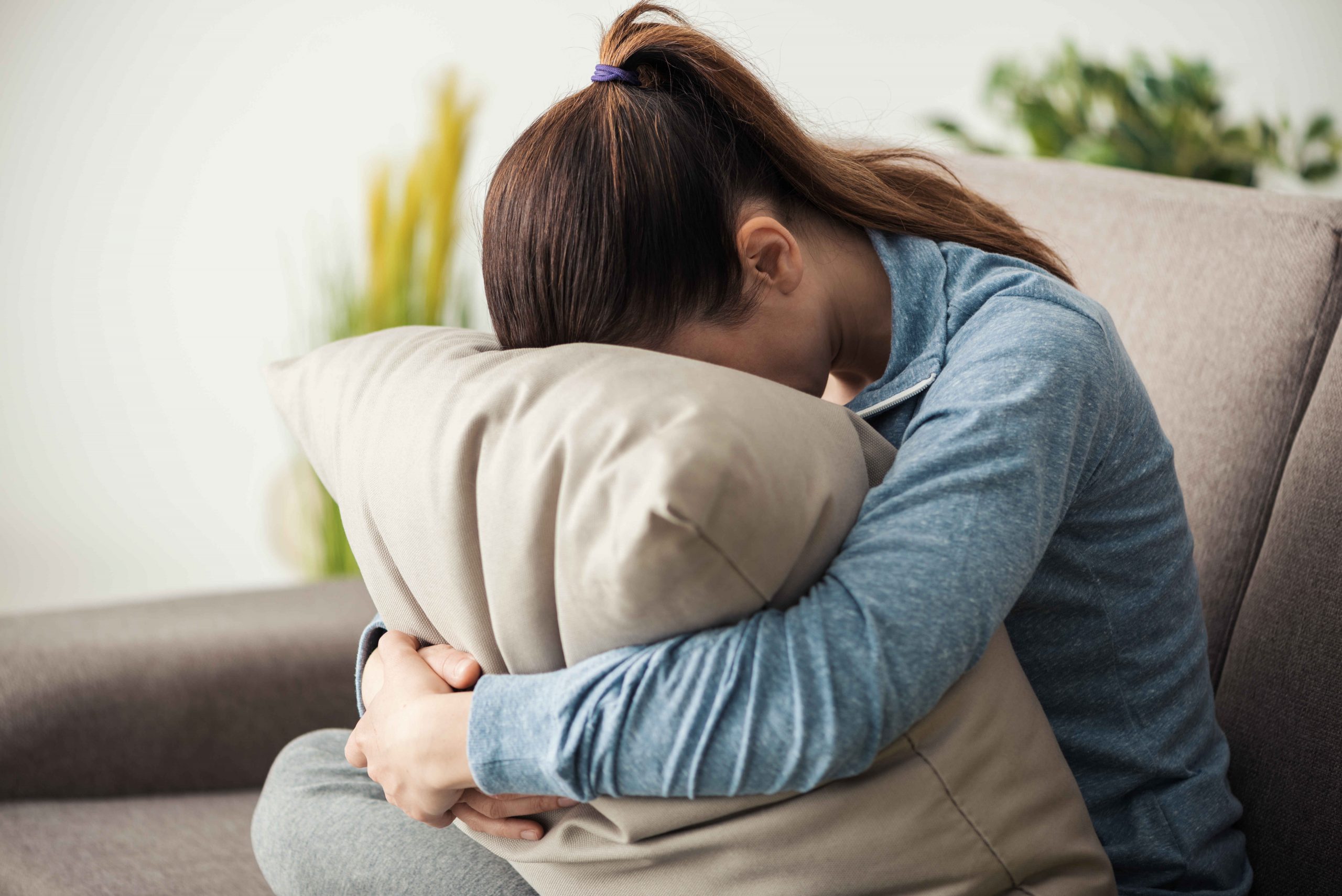 depressed-woman-hiding-her-face-on-a-pillow