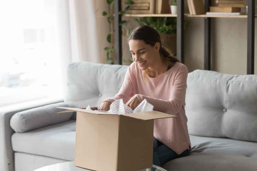 happy-woman-on-the-couch-opening-a-box