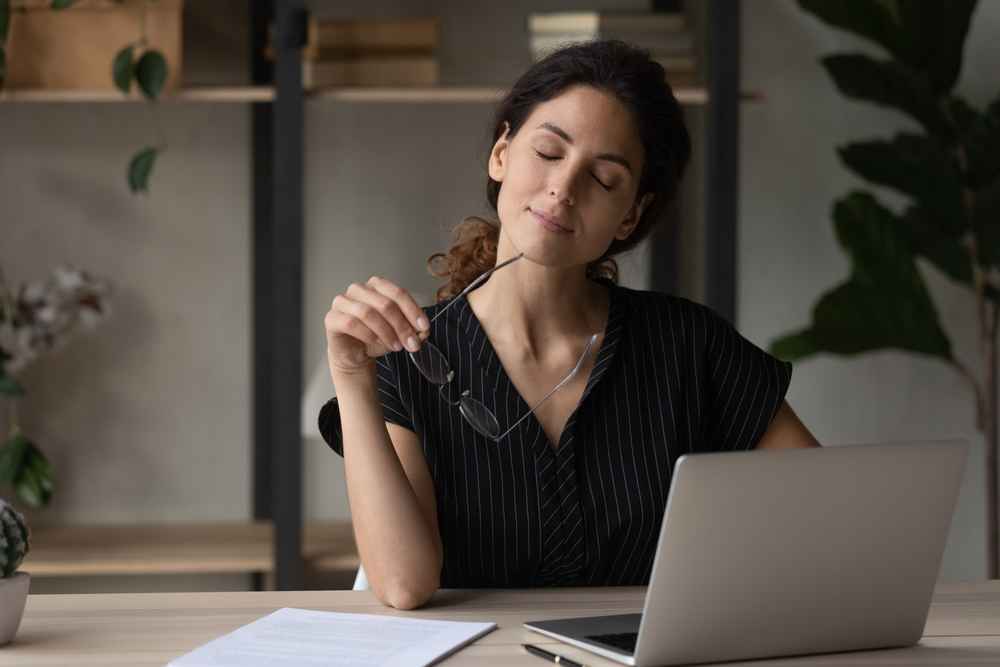 woman on work break smiling with closed eyes