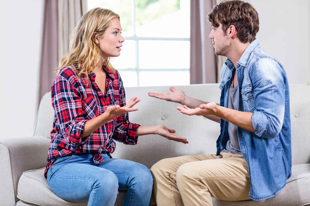 couple having an argument on the sofa