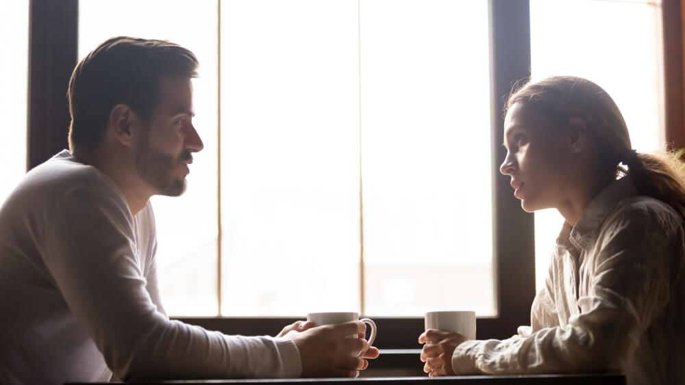 man and woman having a serious conversation at cafe