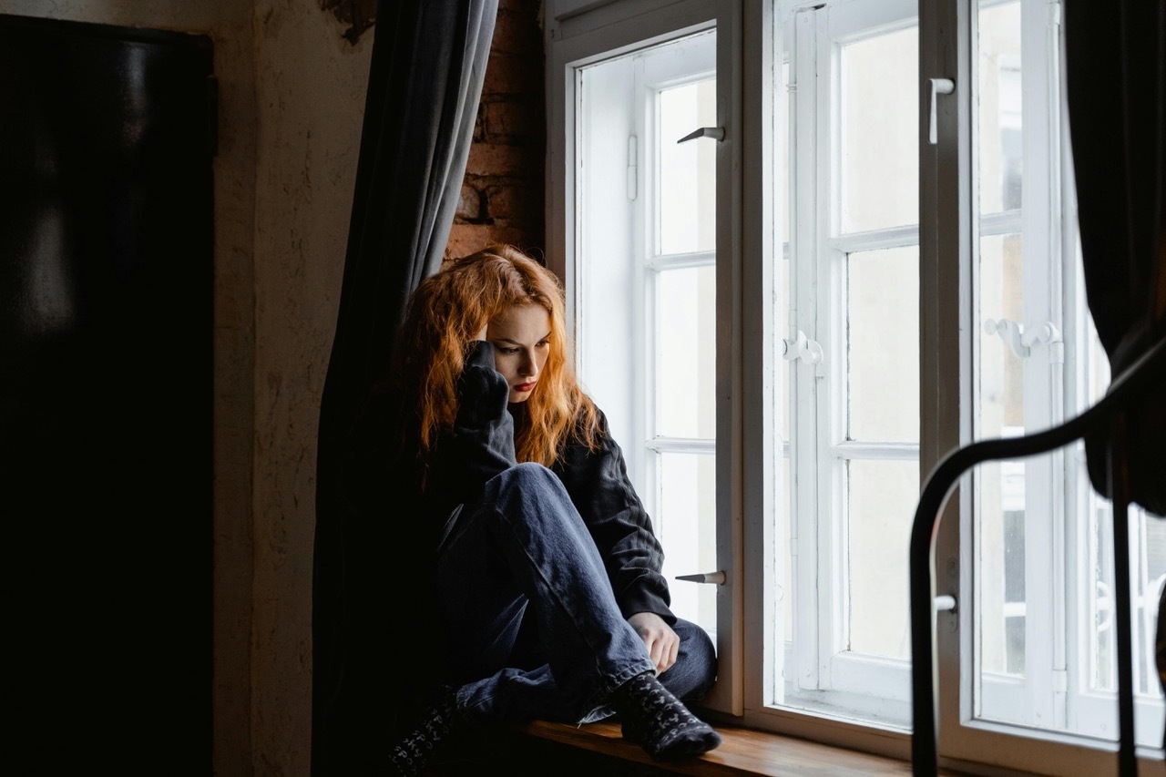 Overthinking Woman Sitting By Window