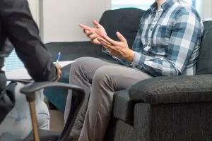 man-talking-and-waving-hands-in-therapy-session-with-life-coach